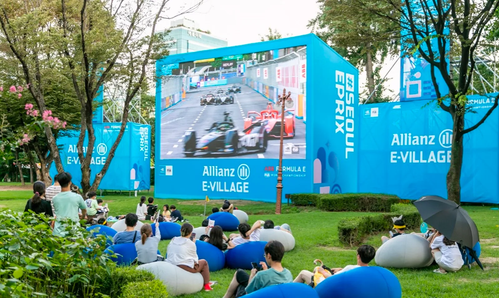 Allianz E-Village에서 Formula E 경주를 대형 화면으로 시청하는 관객들